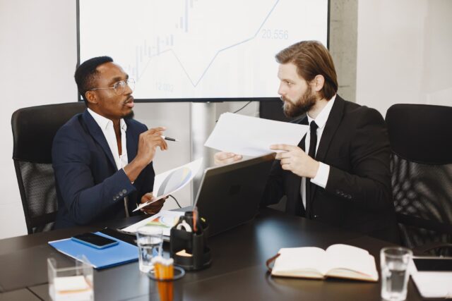 Two financial services executives in a private confidential meeting discussing a senior level search with Ramax Search and Staffing