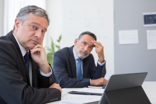 Two financial services executives dealing with the aftermath of an employee resignation and counteroffer decision